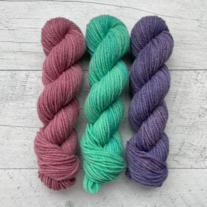 1 trio d'écheveaux de laine québécoise teinte à la main aux couleurs inspirées des années 90. De gauche à droite: rose, vert aqua, violet.