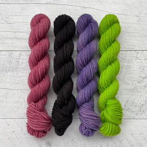 1 ensemble de 4 écheveaux de laine québecoise teinte à la main aux couleurs inspirées des années 90. De gauche à droite: fuchsia, noir, violet et vert néon