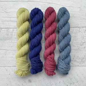 1 ensemble de 4 écheveaux de laine québecoise teinte à la main aux couleurs inspirées des années 90. De gauche à droite: jaune, indigo, fuchsia et bleu
